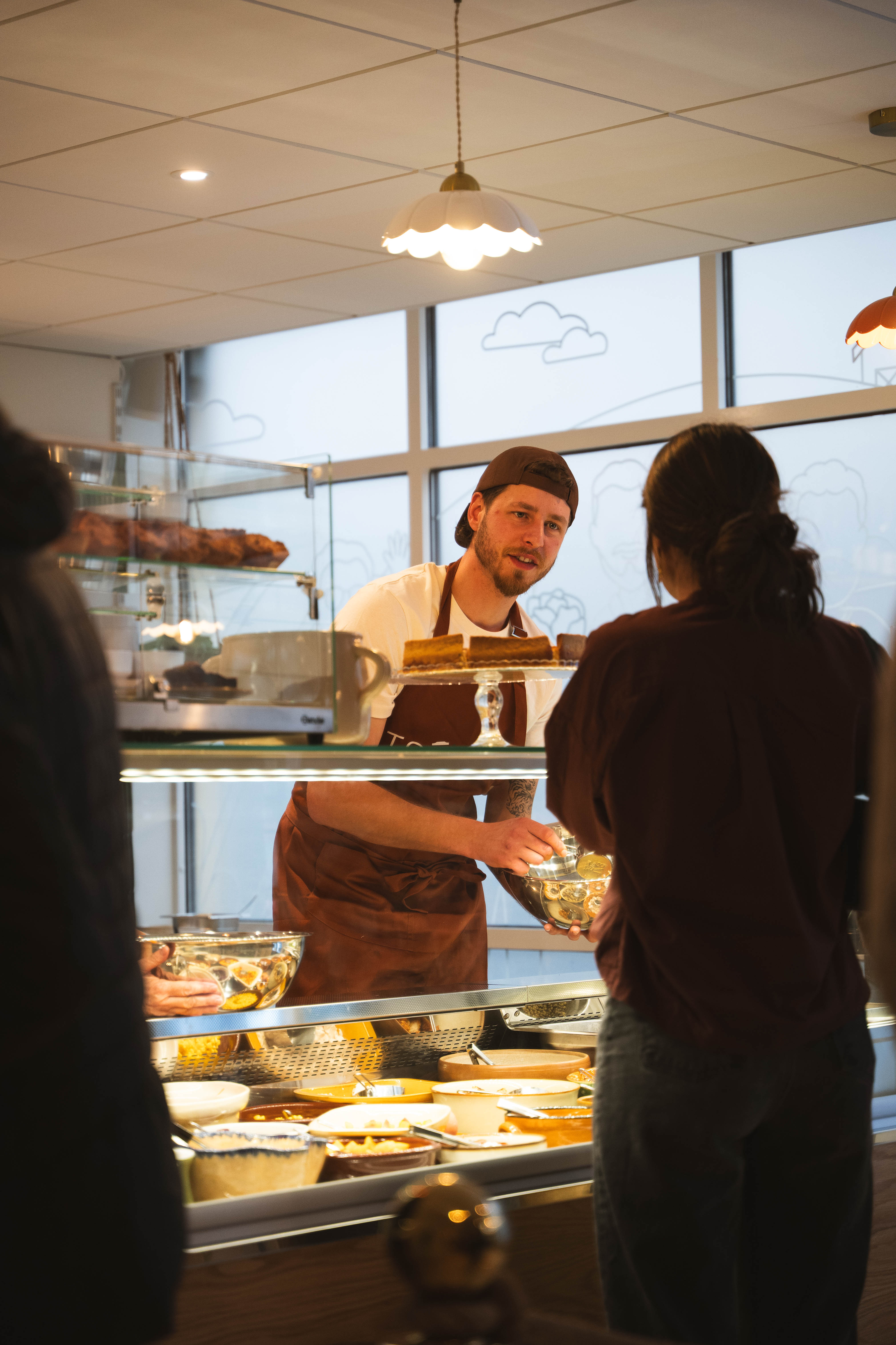 Service au comptoir de Toupine - préparateur face à un client à Rodez